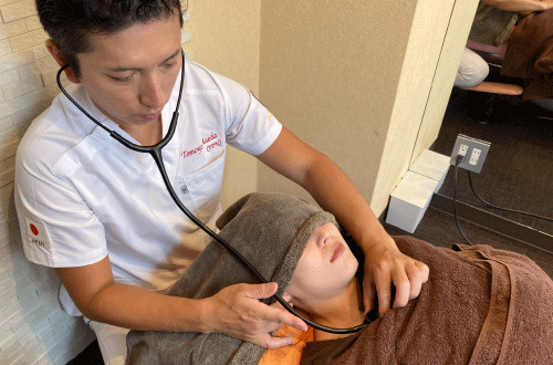 呼吸や胸郭の状態を確認しながら施術しているイメージ